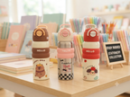 "Hello" series stainless steel vacuum-insulated water bottles 600 ml featuring cute cartoon character graphics and colorful silicone grip bands.